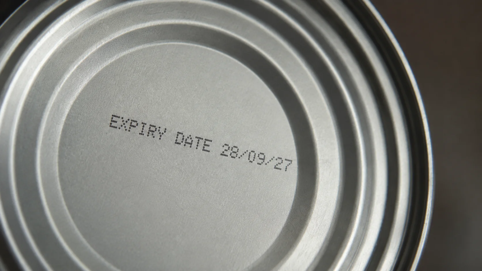 Sealed metal food can and shelf-life date marking Close-up of a sealed metal food can with a printed expiry date