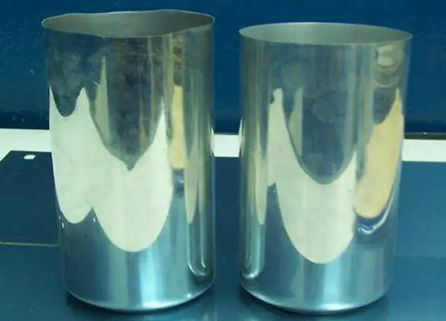 How are aluminum cans made? 6 Aluminum can bodies before trimming showing uneven rim ears formed after ironing process in two-piece can manufacturing