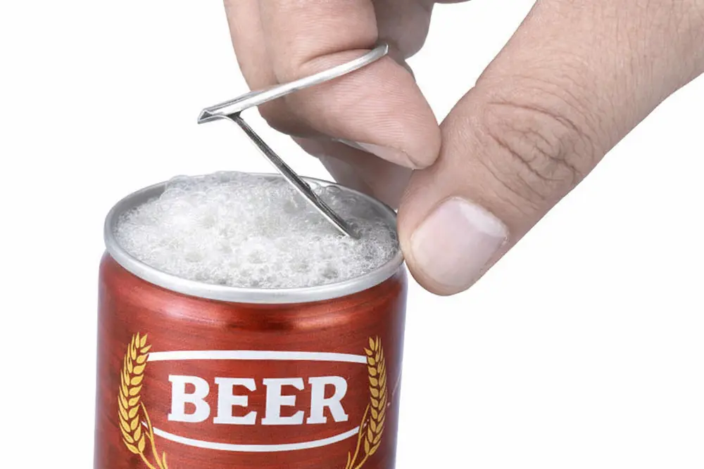 Tirar de la lengüeta para levantar la abertura completa de la lata de cerveza muestra el proceso de apertura y la liberación de la espuma.