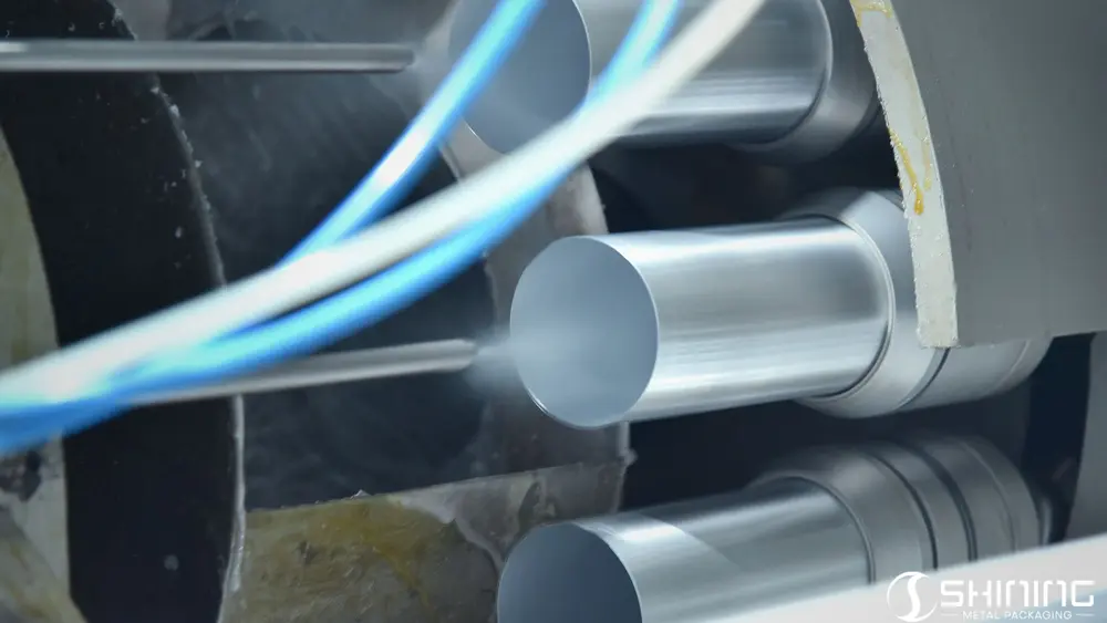 Boquilla de pulverización atomizada que aplica una capa protectora interna en el interior de botellas de aluminio.