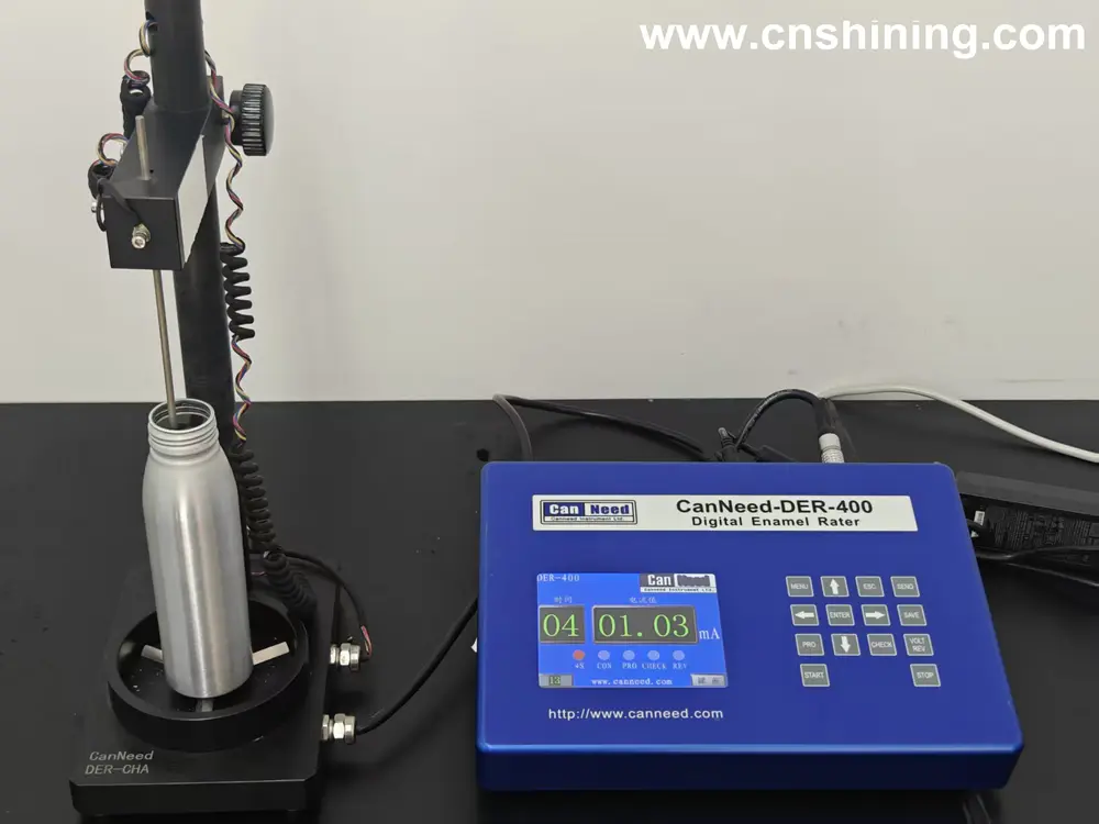 A digital CanNeed-DER-400 enamel rater station measuring the internal coating integrity of an aluminum aerosol bottle.