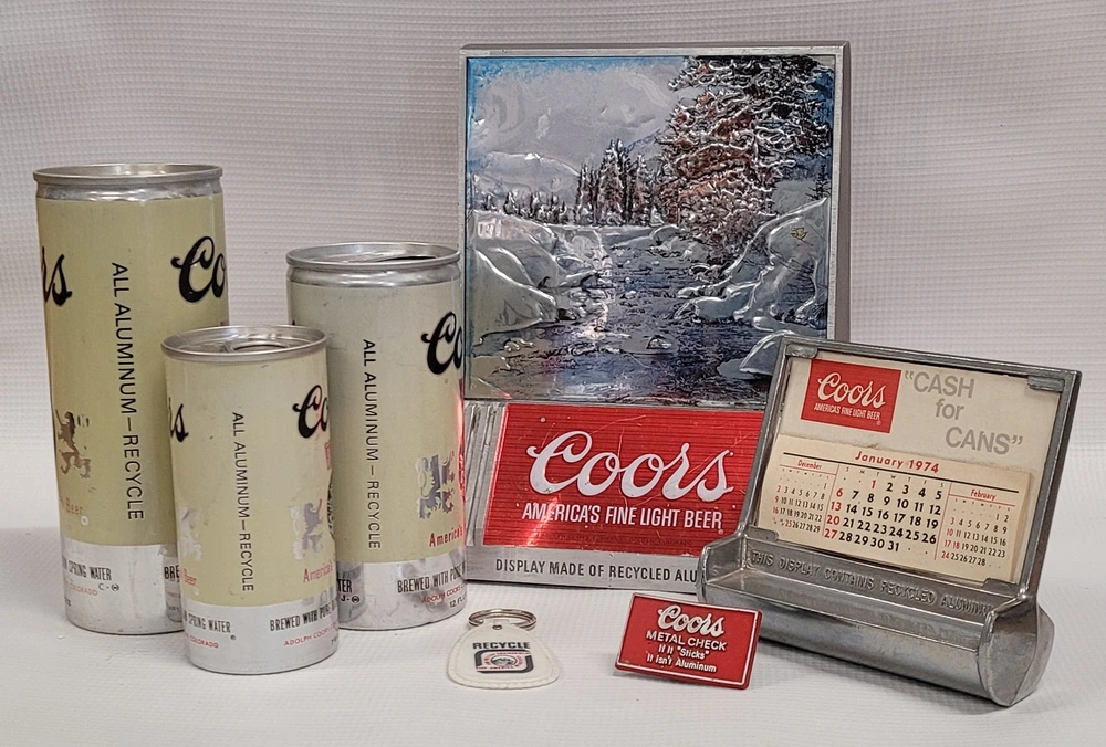 Latas vintage de cerveja Coors, totalmente em alumínio, mostrando a adoção inicial de latas de alumínio e a promoção da reciclagem nos anos 1970.